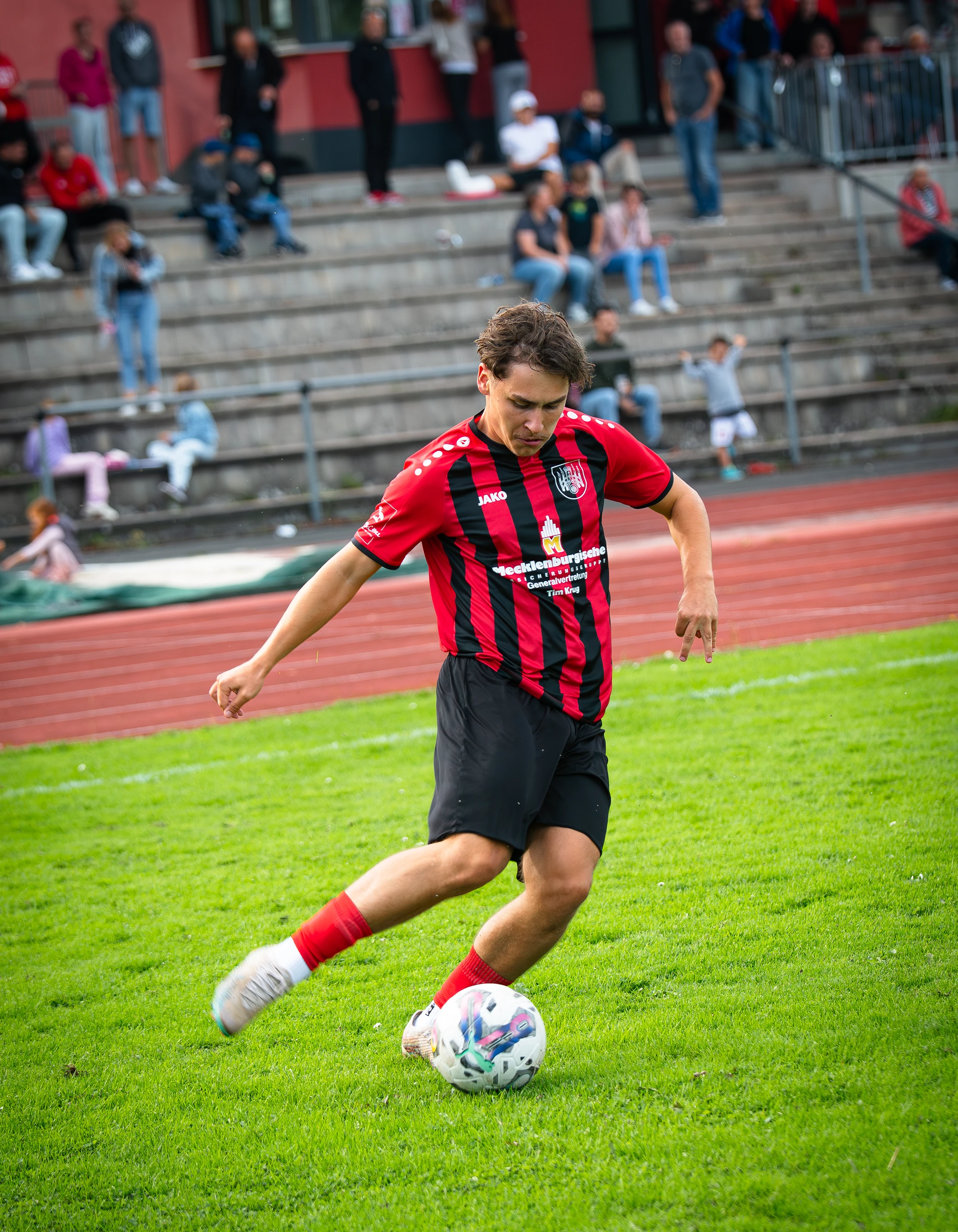 Spieler der TSG Hofgeismar im rot-schwarzen Trikot beim Schuss